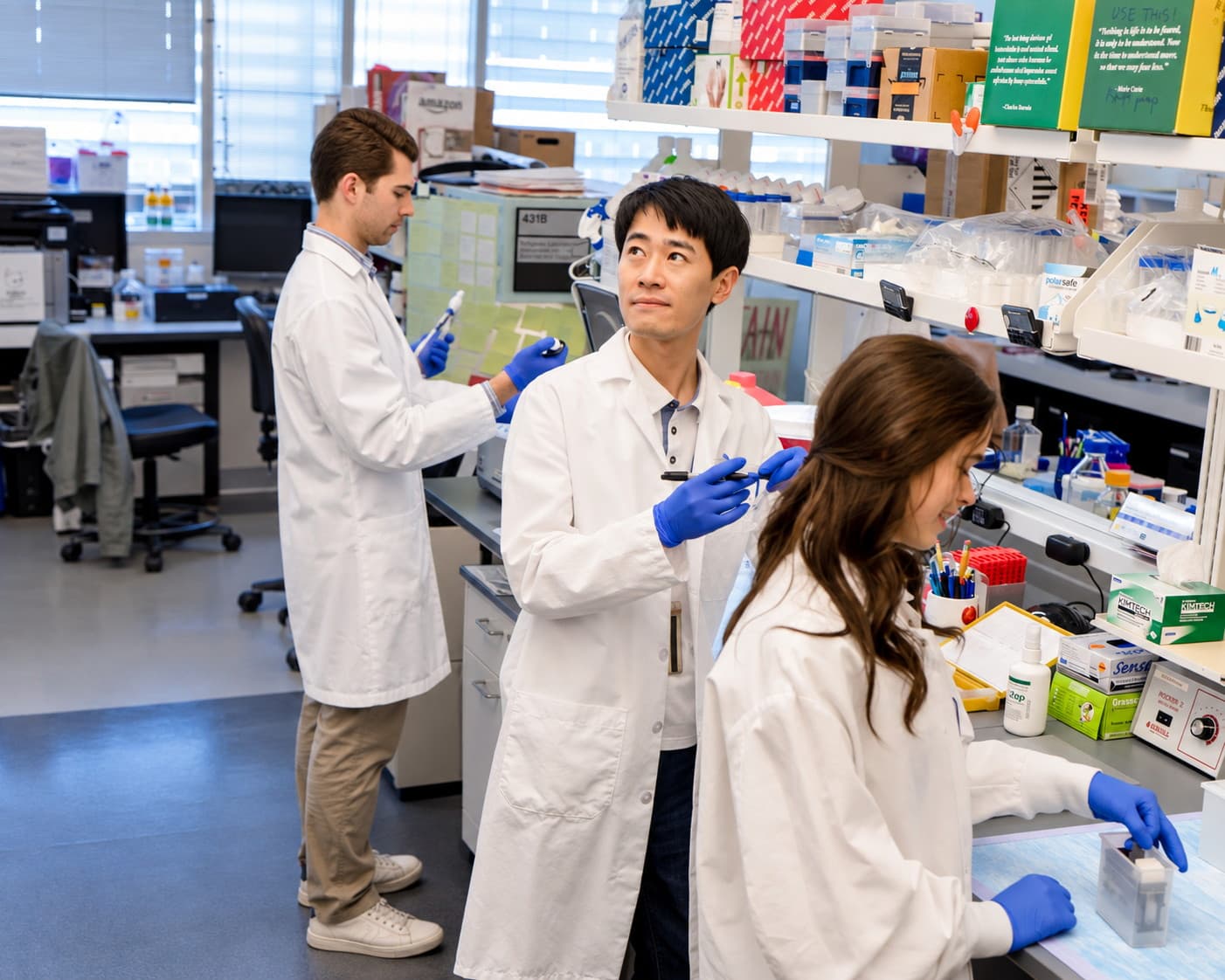 Three lab members at work at the bench
